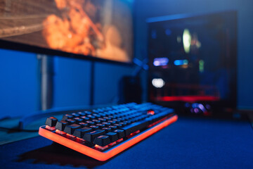 Close up of personal cyber video gamer equipment, powerful gaming computer, keyboard for stream, mouse, monitor in neon color. Blur background. Soft focus. Cyber sport, esport, modern technology © Arsenii