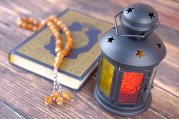 Holy book Quran and rosary on table, close up.