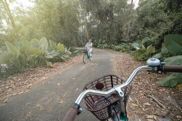 Fototapeta na wymiar Happy woman riding bicycles along road in summer.