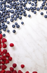 still life with blueberries, strawberries and raspberries on a white patterned background