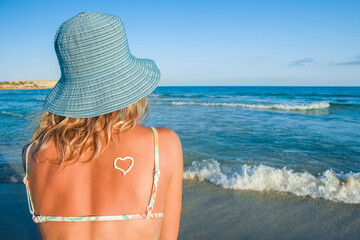happy girl with a heart on her back by the sea outdoors
