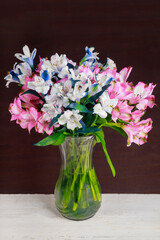 Pink and white alstroemeria in glass vase.