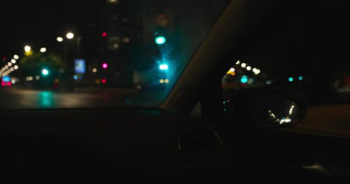 Espejo retrovisor de coche en marcha con luces de ciudad desenfocadas