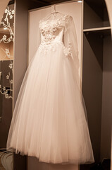 Fototapeta na wymiar The wedding dress is hanging on a hanger