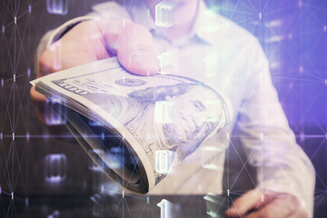 Double exposure of technology drawing hologram and us dollars bills and man hands. Data concept