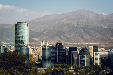 Skyline of modern buildings at financial district with The Andes mountain range in the back.
