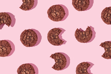 Creative pattern made with chocolate chip cookies on pastel pink background. Happy sweet fun life idea. Trendy food or dessert concept. Spring or summer layout.