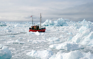 Fishing boats are breaking through icebergs in the Arctic Ocean. © minspa