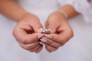 Gold ring with a stone in the hands of the bride