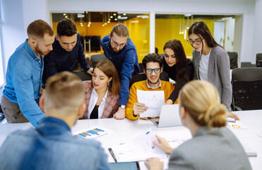 Group of young businesspeople working together in creative office. Young people are discussing a new business project in the office. Planning, analysis, collaborate work in teamwork.