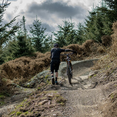 Obraz premium Mountain biker pushing his bike uphill
