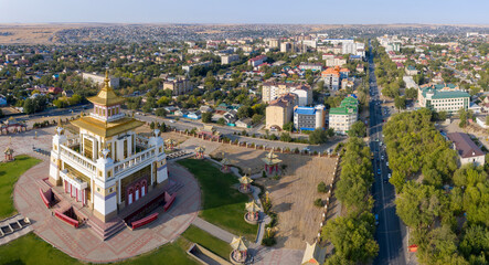 Fototapeta na wymiar Panoramic aerial view of Golden Temple of Buddha Shakyamuni and Lenin street on sunny day. Elista, Kalmykia, Russia.