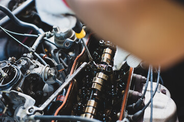 Fototapeta premium The mechanic is repairing and tuning the car's engine.