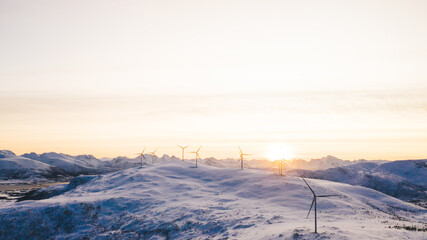 Windmills on ridge with snow in shiny sunlight
