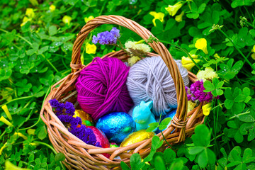 Fototapeta na wymiar Easter eggs with a rabbit in a basket between vegetation