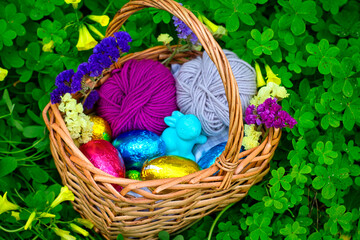 Easter eggs with a rabbit in a basket between vegetation