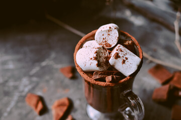 Hot chocolate and marshmallows. Hot Cocoa in a white cup. Dark background. Copy space. Steam from a cup.