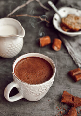 Hot chocolate and marshmallows. Hot Cocoa in a white cup. Dark background. Copy space. Steam from a cup.