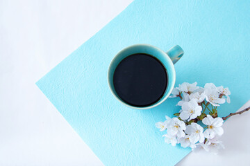 Obraz na płótnie Canvas 桜の花束とターコイズブルーのコーヒーカップ（水色の和紙）