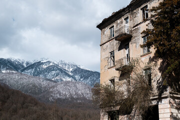 Destroyed abandoned house after the war against the snowy mountains. Broken