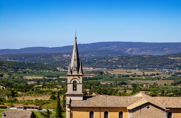 Fototapeta na wymiar Bell tower from close in a cute little village in provence with a countryside landscape in France as background by a wonderful cloudless sunny day 