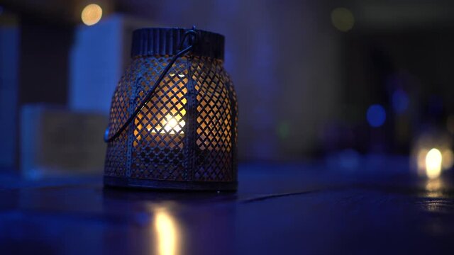 Beautiful oriental arabian candle lit perforated lamp on corridor with evening blue ambiant