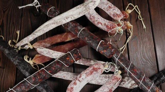 Close-up of set of different dry sausages on a wooden background. Spanish salami