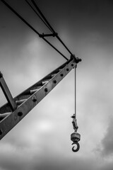 Lifting crane against a cloudy sky in black and white