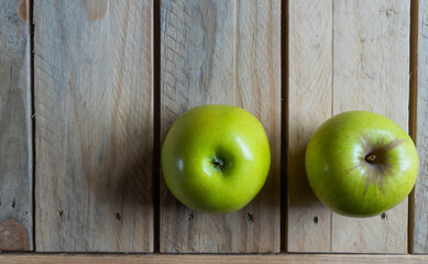 Manzanas verdes sobre pizarra y madera