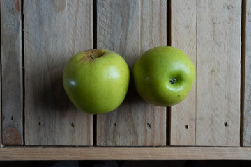 Manzanas verdes sobre pizarra y madera