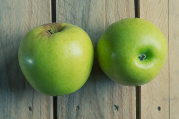 Manzanas verdes sobre pizarra y madera