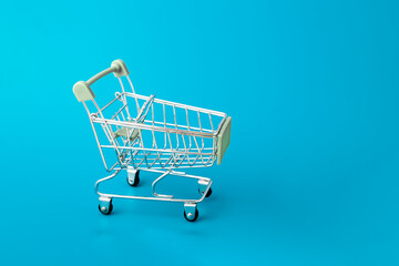 Shopping cart, supermarket trolley on blue background