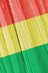 The flag of Bolivia on dry wooden surface, cracked with age. Vertical background, wallpaper or...