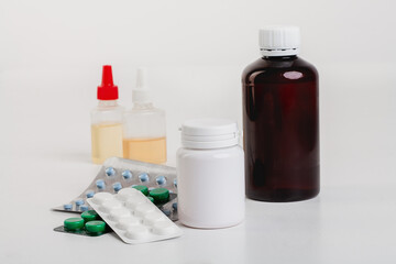 Medical pills and drugs in multi-colored packages on a white table