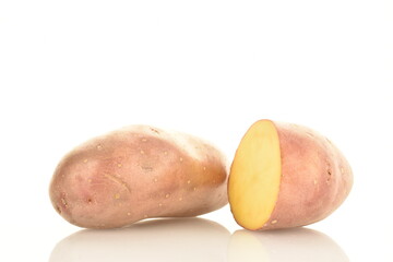 One whole and one half of an unpeeled raw potato, close-up, isolated on white.