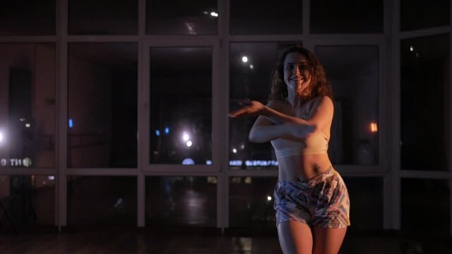 Sexy woman dances a seductive dance. Twerk. Beautiful girl dancing in the studio at night. Hip-Hop. Erotic dances.