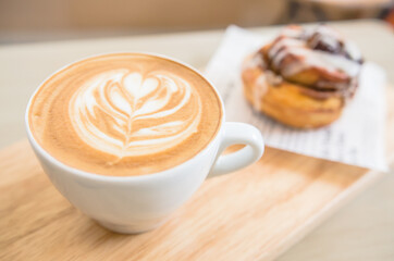 Cinnamon Roll with coffee latte on a wooden table.