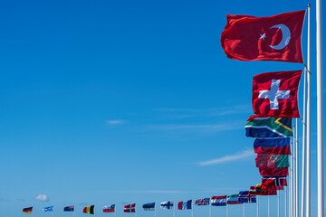 International flags waving with clear blue sky.