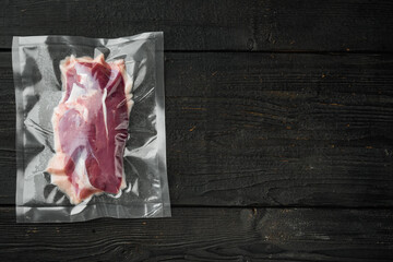 Raw duck breast in seal bag for sous vide cooking, on black wooden table background, top view flat lay, with copyspace  and space for text