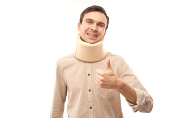 Portrait of caucasian man with neck bandage showing thumbs up isolated in studio, injury and fracture