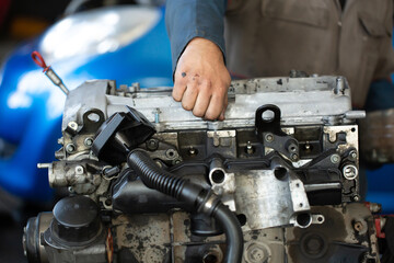 Master, car mechanic repairs the car engine at the service station