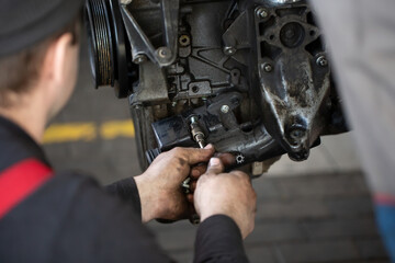 Fototapeta na wymiar Auto mechanic checking an internal combustion engine