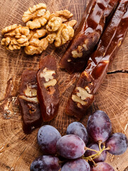 Churchkhela, national Georgian dessert made from grape juice and walnuts, composition on a wooden table