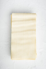 Dried uncooked lasagna pasta sheets, on white stone  background, top view, flat lay