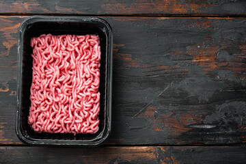 Raw Minced Meat in a Black Plastic Container, on old dark  wooden table background, top view, flat lay, with copy space for text