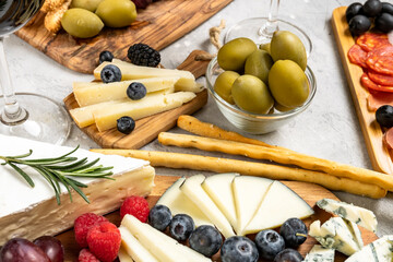 Food snacks for an Easter family dinner or party: сharcuterie board with pork sausage, salami, parmesan, pecorino, gorgonzola cheese and berries, olives and and grissini breadsticks. Top view