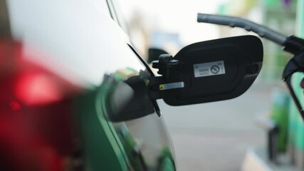 Refueling a car at a gas station. Hand holding and recording the process. Fuel, gas station, petrol prices concept. Gasoline, gas, fuel, petroleum concept. Filling car with gas fuel at station pump - Powered by Adobe