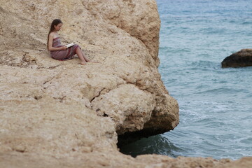 Fototapeta na wymiar Nice person in the sea and reads a book on the beach