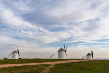 three whitewashed traditional Spanish windmills on the plains of La Mancha
