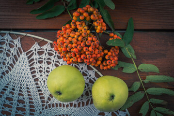 mountain ash and apples on the autumn table and a napkin